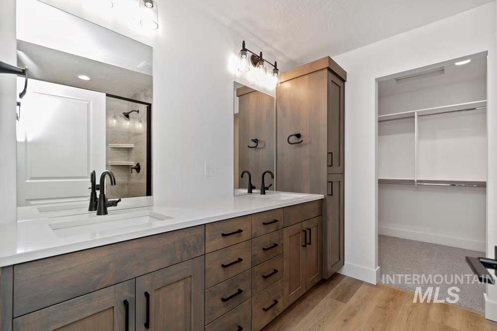 744 South Calhoun Lane Star, ID 83669 - Photo 10 of 34 Bathroom with double vanity, light wood-style floors, a walk in closet, recessed lighting, and a shower