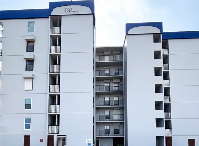 a kitchen with stainless steel appliances a refrigerator a sink and white cabinets