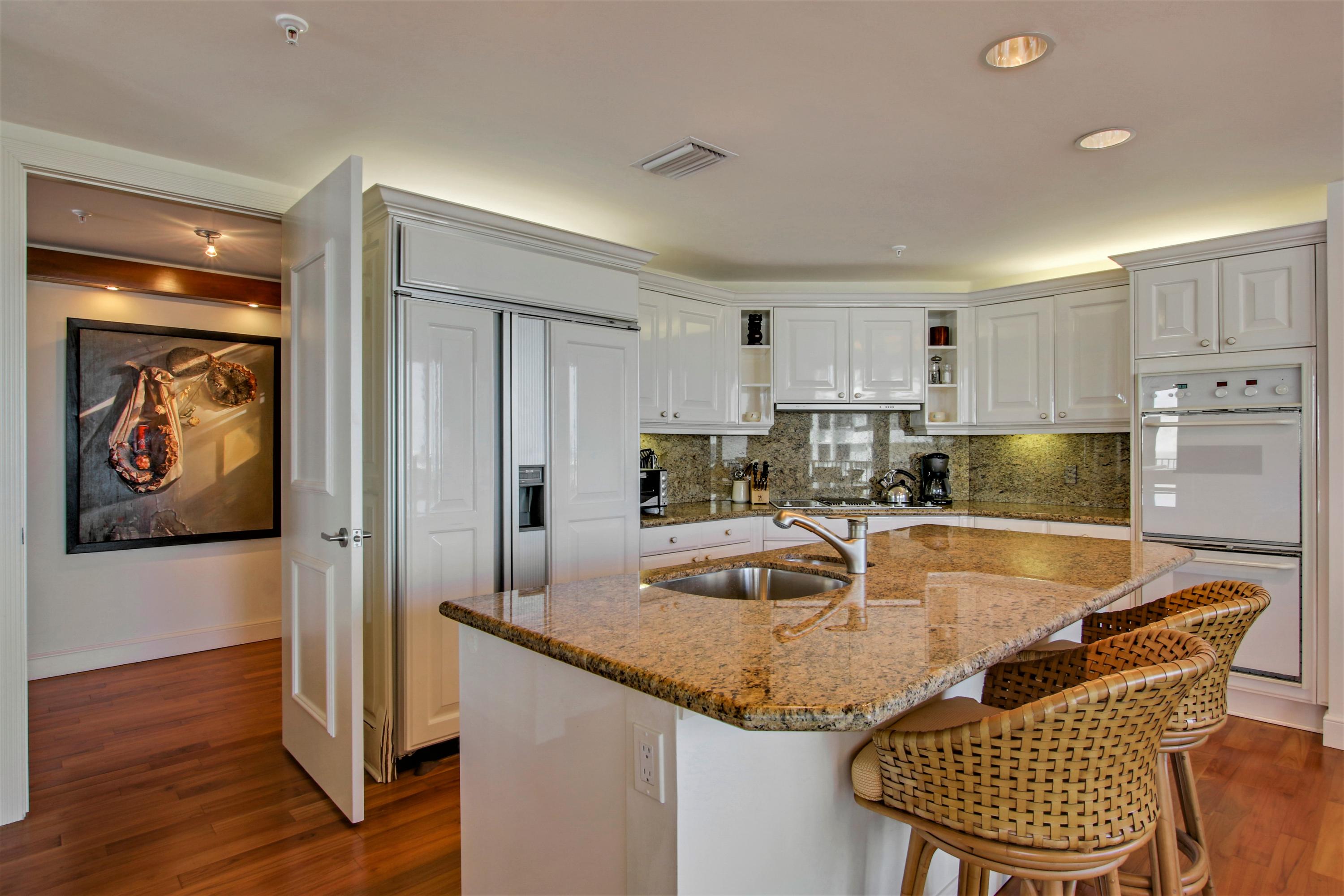 570 Ocean Drive, Unit 601 Juno Beach, FL 33408 - Photo 14 of 35 a kitchen with granite countertop a sink and refrigerator