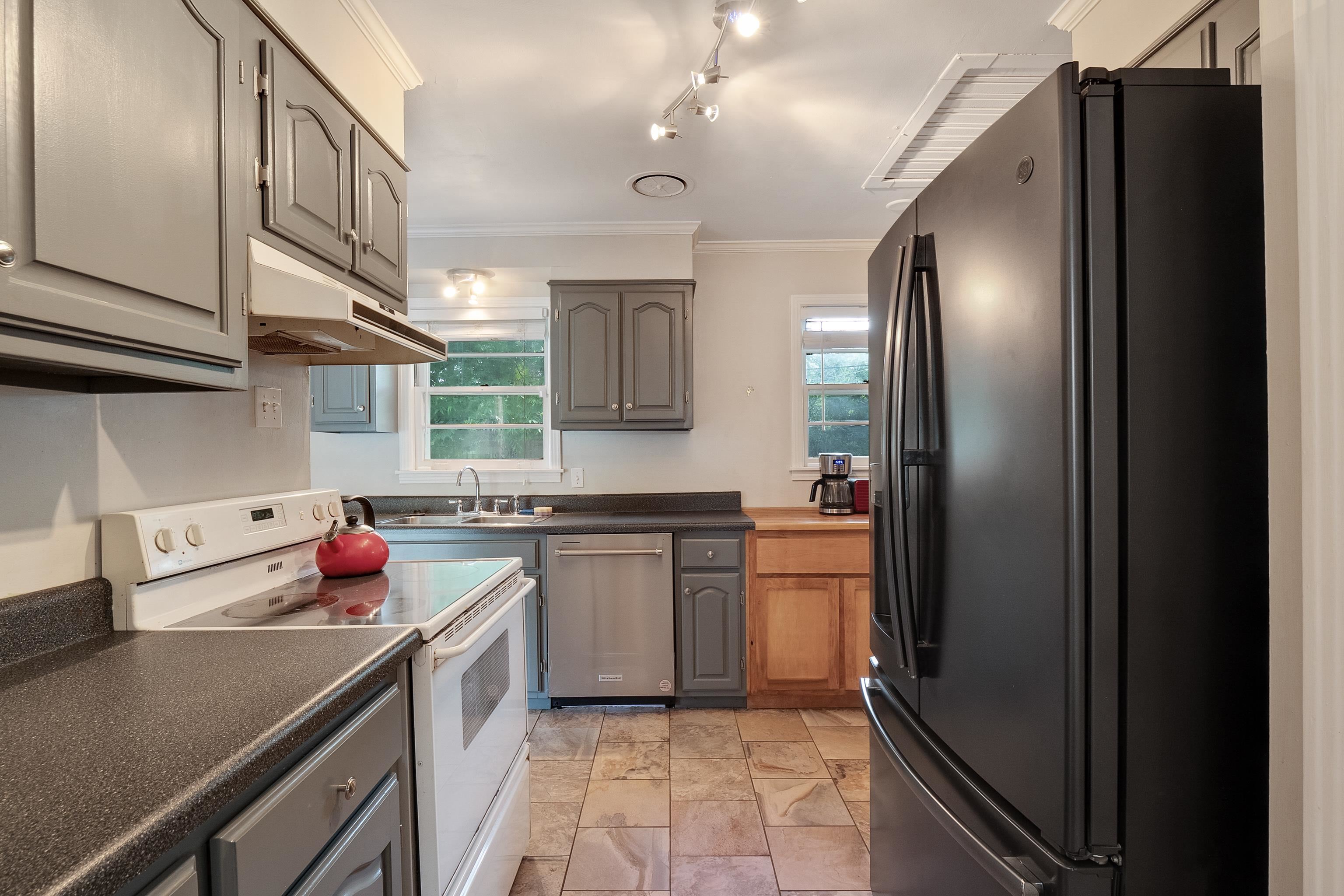 5069 Quince Road Memphis, TN 38117 - Photo 11 of 25 a kitchen with stainless steel appliances granite countertop a refrigerator a sink dishwasher a stove with wooden cabinets