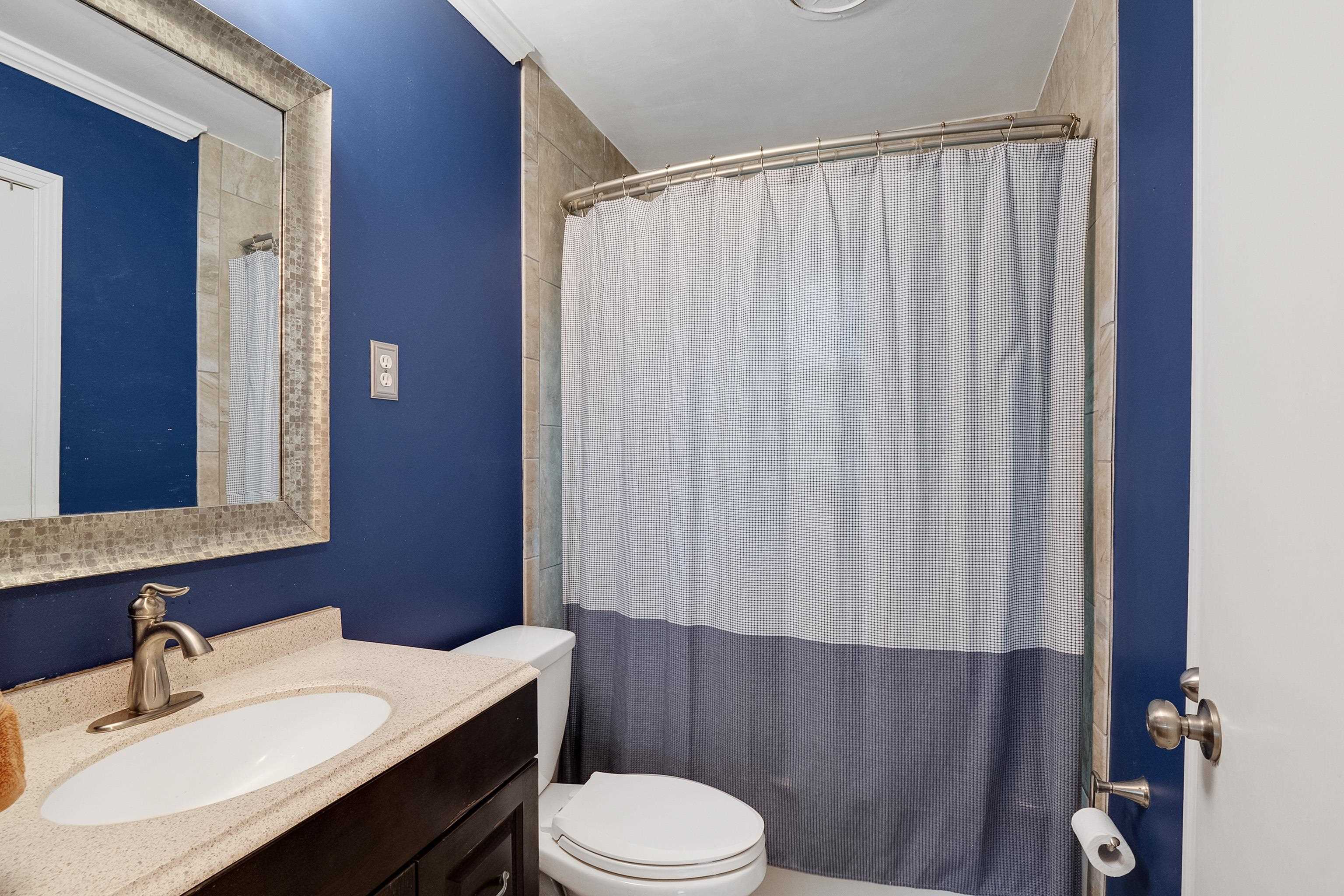 5069 Quince Road Memphis, TN 38117 - Photo 18 of 25 a bathroom with a sink a toilet a mirror and shower curtain