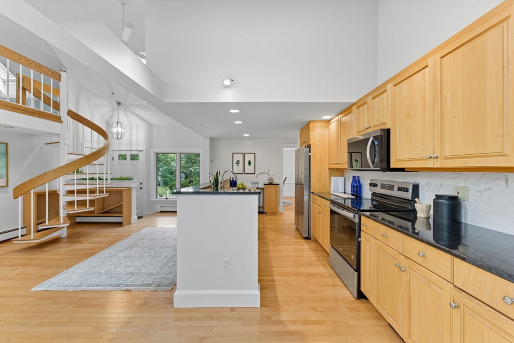 22 Burlington Street Lexington, MA 02420 - Photo 5 of 32 a kitchen with stainless steel appliances granite countertop a refrigerator a stove top oven a sink dishwasher and wooden cabinets with wooden floor