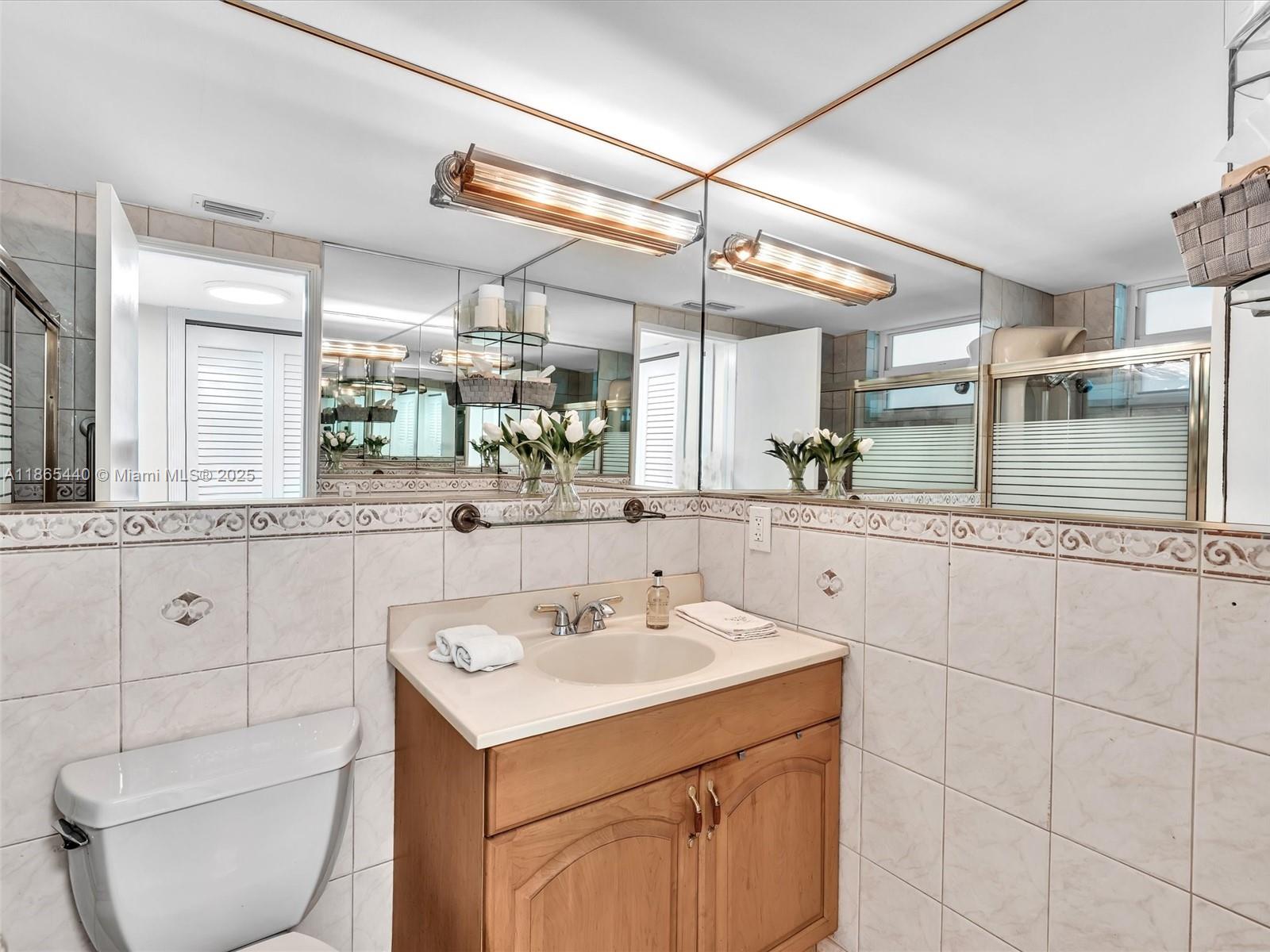 301 Sunrise Drive, Unit 1DW Key Biscayne, FL 33149 - Photo 14 of 40 a bathroom with a sink mirror and toilet