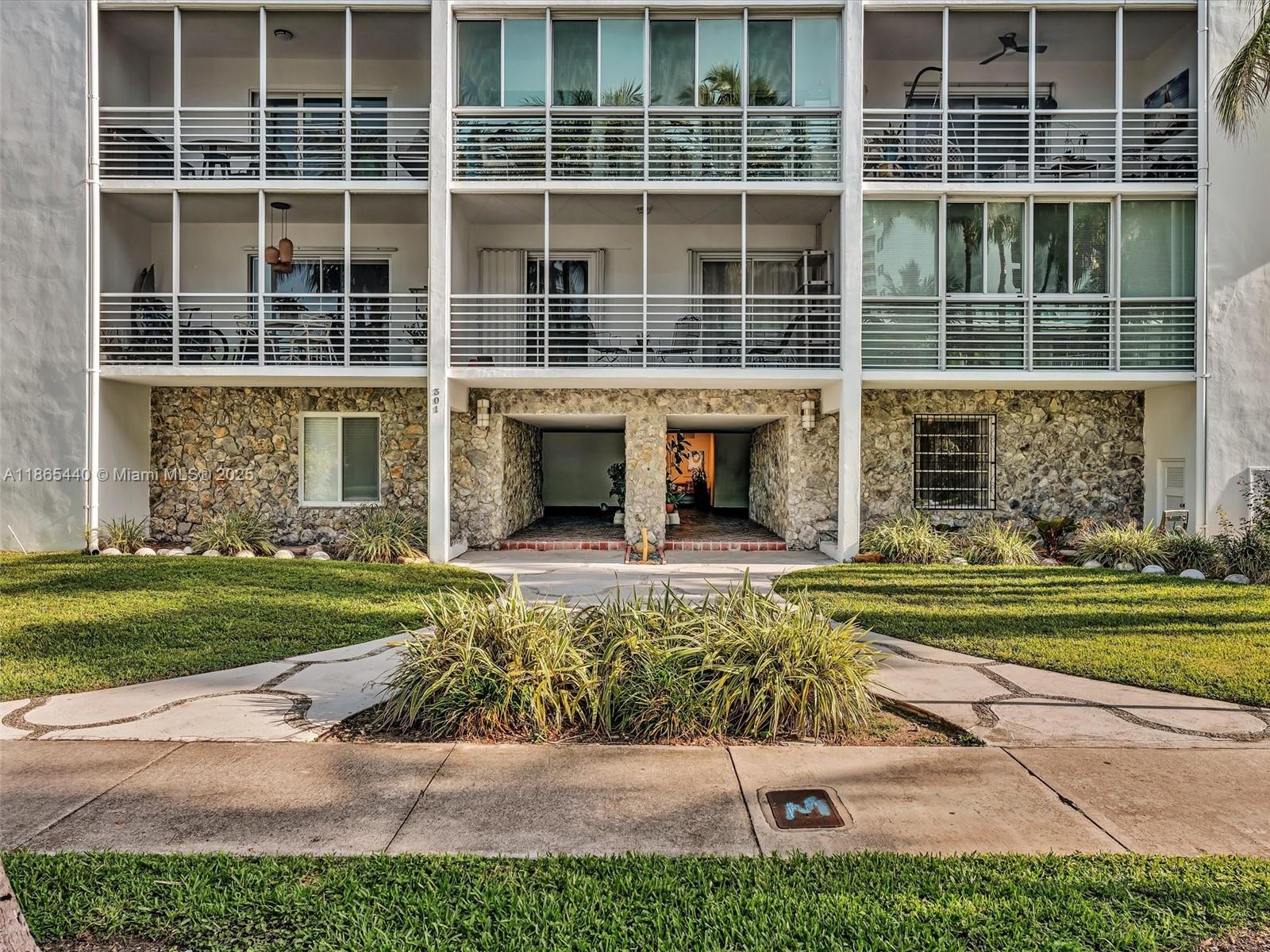 301 Sunrise Drive, Unit 1DW Key Biscayne, FL 33149 - Photo 2 of 40 a front view of a building with a garden and trees