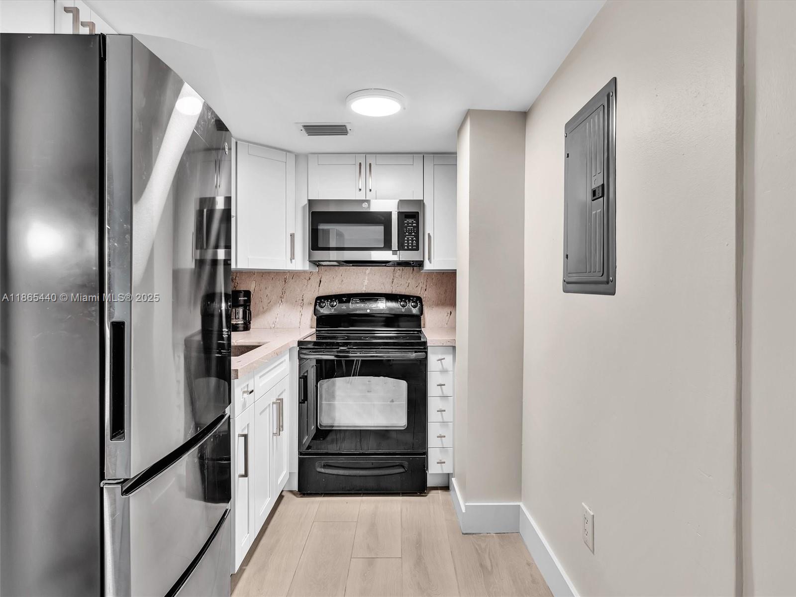 301 Sunrise Drive, Unit 1DW Key Biscayne, FL 33149 - Photo 5 of 40 a kitchen with stainless steel appliances a refrigerator stove and microwave