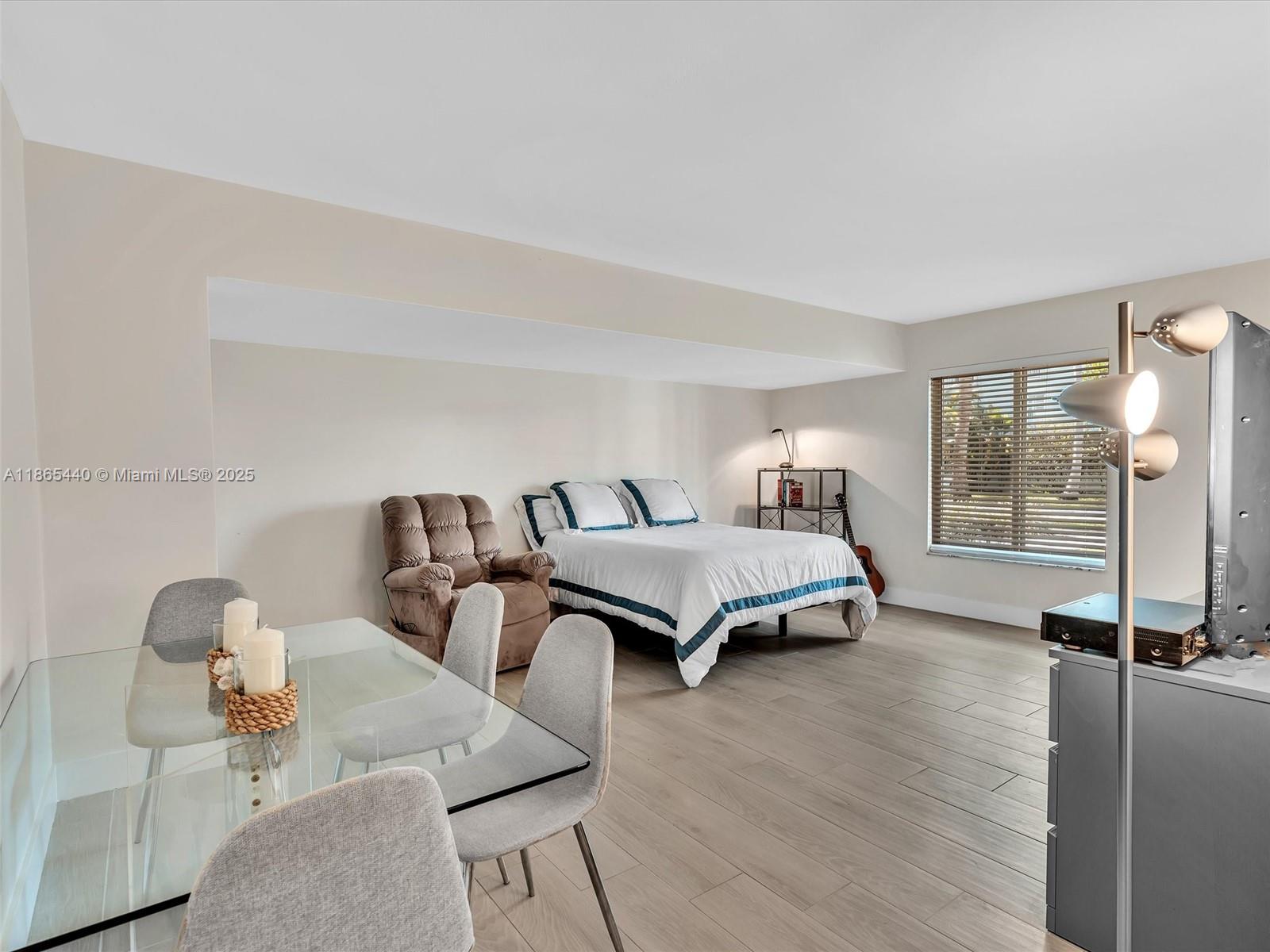 301 Sunrise Drive, Unit 1DW Key Biscayne, FL 33149 - Photo 8 of 40 a bedroom with furniture and wooden floor