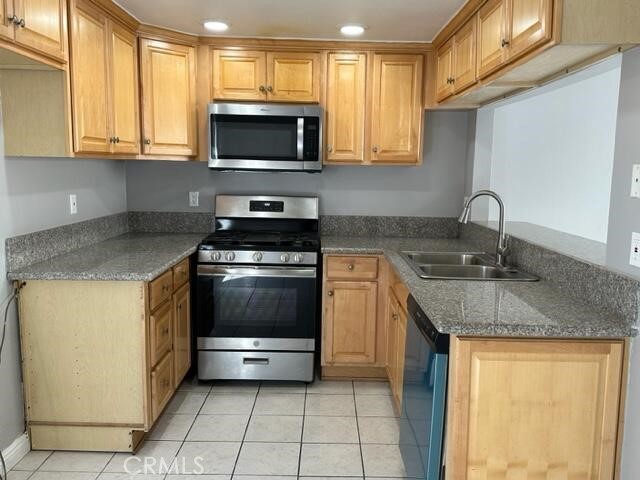 16115 3/4 Eucalyptus Avenue, Unit A Bellflower, CA 90706 - Photo 5 of 17 a kitchen with stainless steel appliances granite countertop a sink stove and microwave