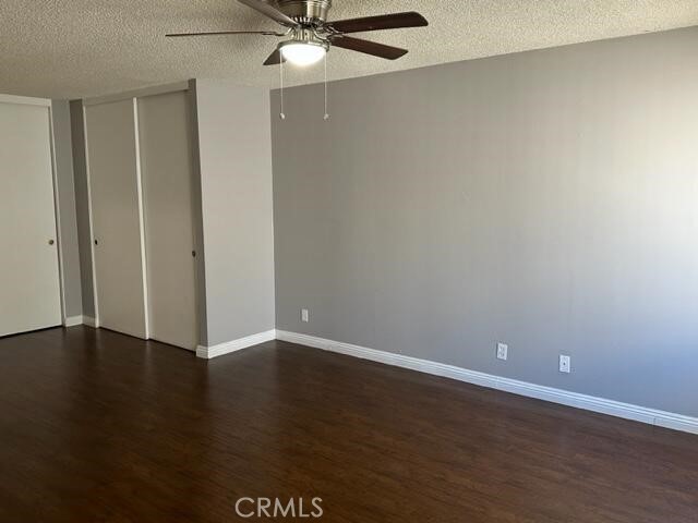 16115 3/4 Eucalyptus Avenue, Unit A Bellflower, CA 90706 - Photo 8 of 17 an empty room with wooden floor and fan