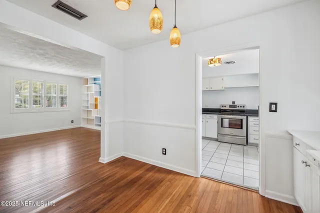 a kitchen with granite countertop a sink stove and cabinets