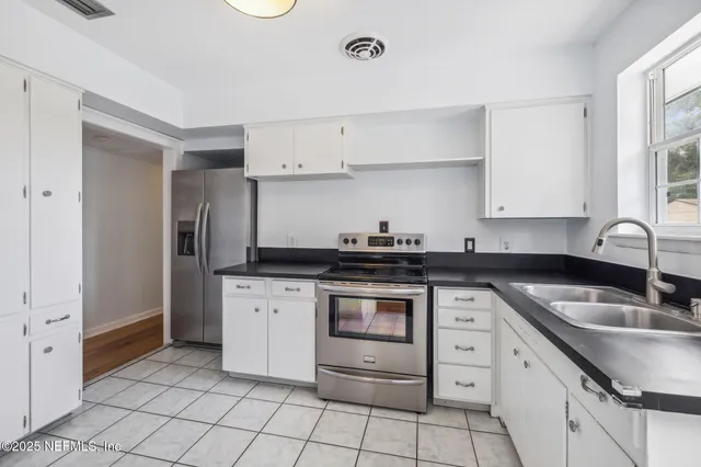 a kitchen with granite countertop white cabinets and appliances