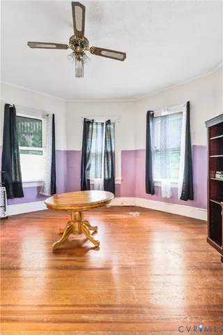 a view of a livingroom with wooden floor a ceiling fan and window