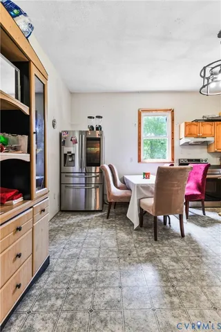 a living room with furniture a flat screen tv and a refrigerator
