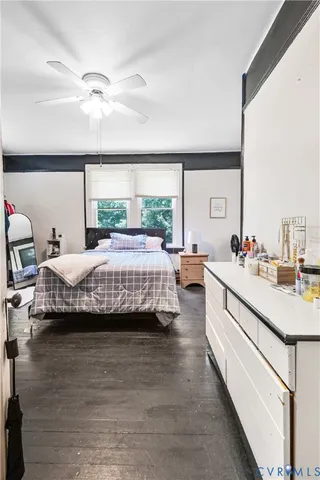 a bedroom with a bed wooden floor and window