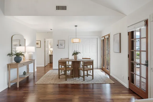 a dining room with furniture potted plants and wooden floor