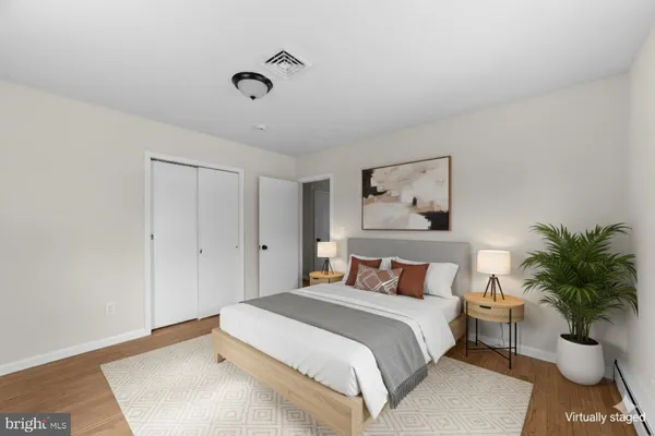 a bedroom with a large bed and a potted plant