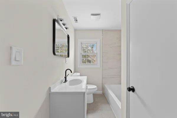 a bathroom with a sink and mirror with toilet