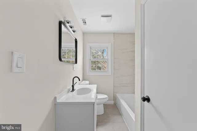 a bathroom with a sink and mirror with toilet