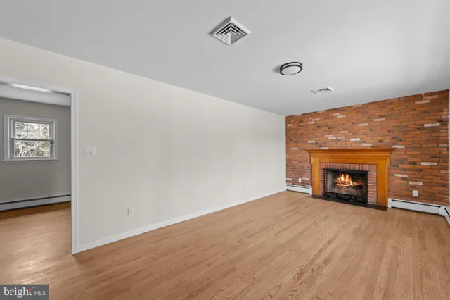 an empty room with a fireplace and window