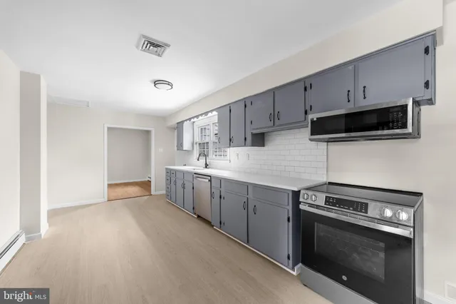 a kitchen with stainless steel appliances white cabinets and a sink