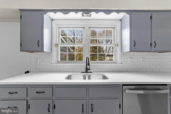 a sink with white cabinets