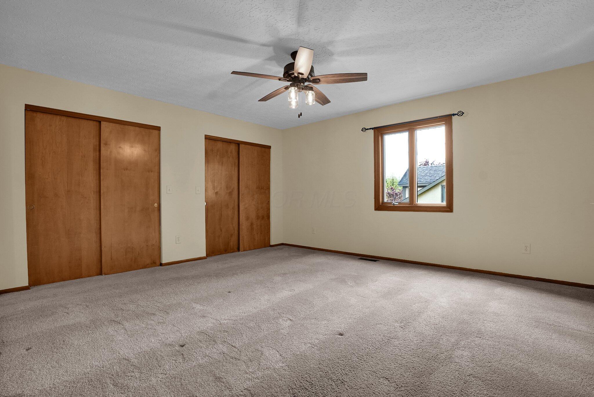 623 Rockbridge Road Westerville, OH 43081 - Photo 26 of 63 Primary suite has neutral flooring and two large closets. Updated ceiling fan and light fixture makes for a relaxing space!