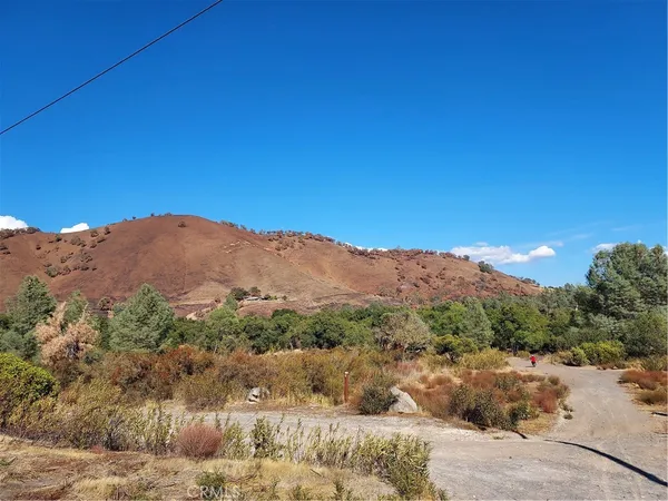 a view of a dry yard with mountains in the background