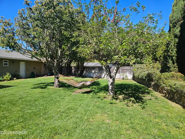 a view of a house with backyard and sitting area