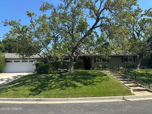 a front view of a house with a yard garage and outdoor seating