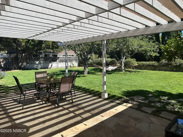a view of a patio with table and chairs under an umbrella