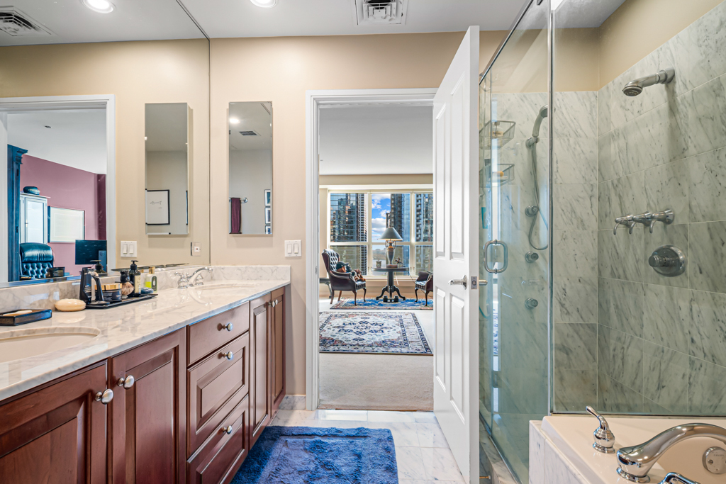 445 East North Water Street, Unit 2003 Chicago, IL 60611 - Photo 6 of 18 a spacious bathroom with a shower sink and mirror