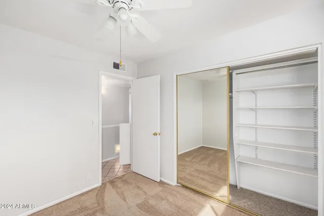 an empty room with a window and a fan