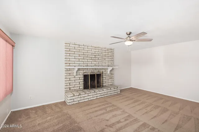 an empty room with windows and fireplace