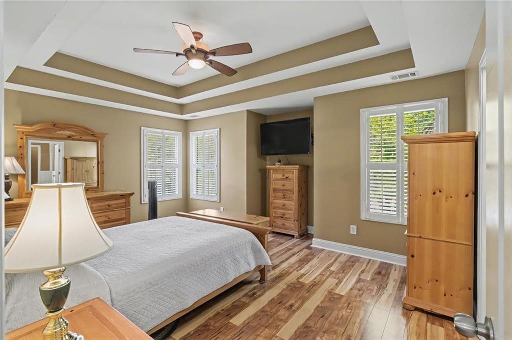 101 Oscar Lane Dallas, GA 30132 - Photo 26 of 55 a bedroom with a large bed a flat tv screen and a chandelier