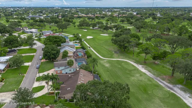an aerial view of residential houses with outdoor space and trees