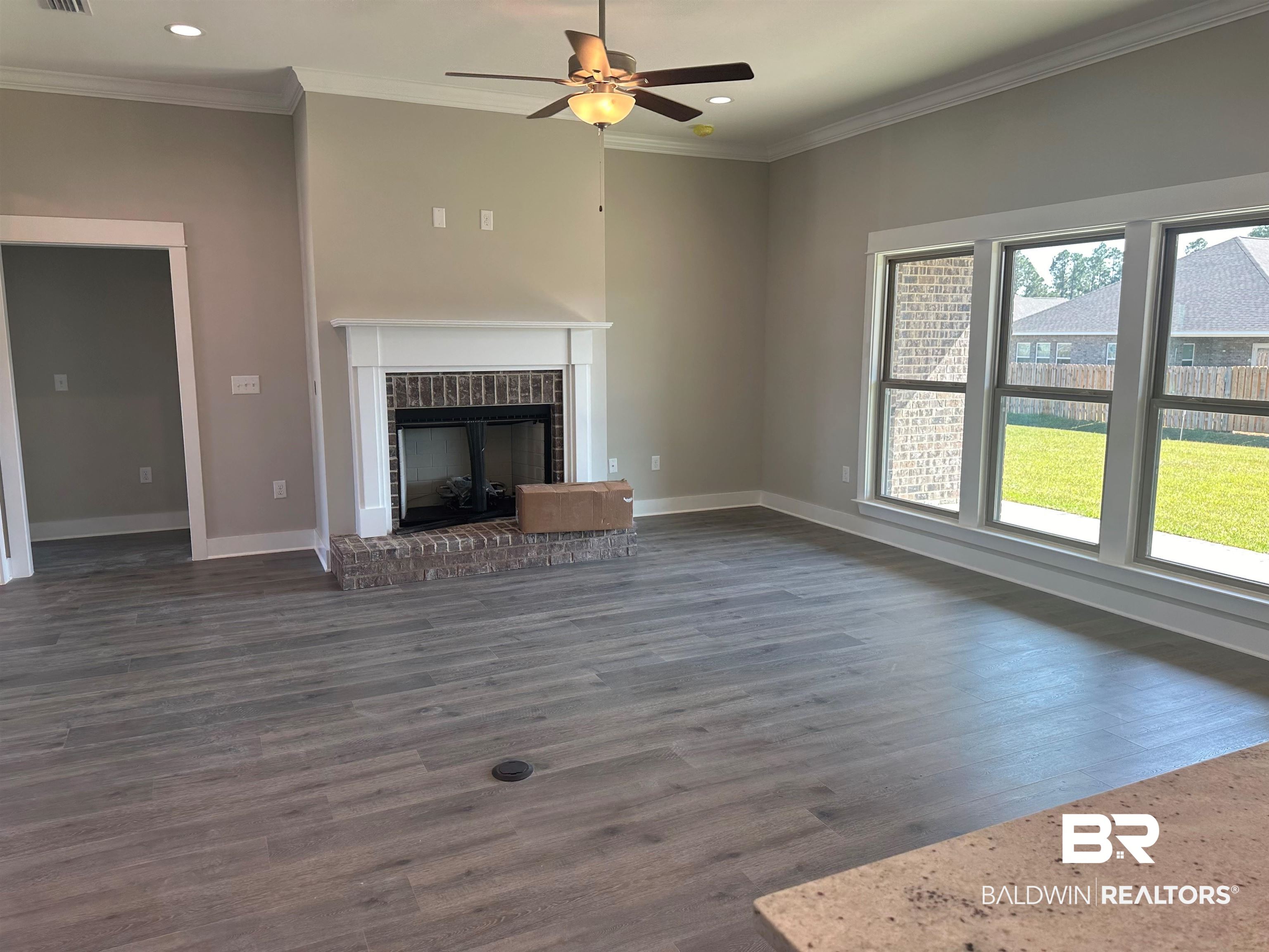 23548 Travis Stock Street, Unit 50 Foley, AL 36535 - Photo 17 of 30 Unfurnished living room with ornamental molding, ceiling fan, a fireplace, and dark hardwood / wood-style flooring