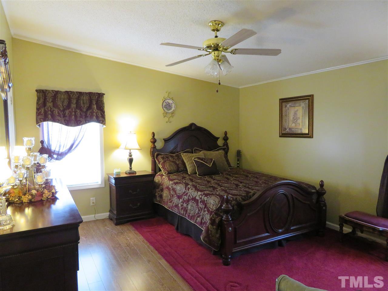 4481 Pixley Pritchard Road Timberlake, NC 27583 - Photo 15 of 25 a bedroom with a bed and a chandelier