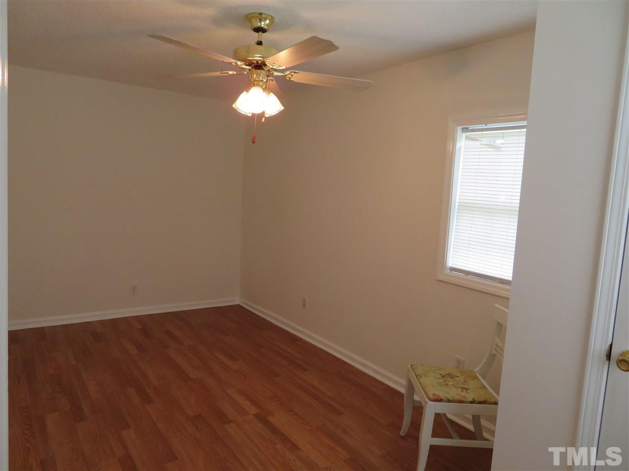 4481 Pixley Pritchard Road Timberlake, NC 27583 - Photo 22 of 25 an empty room with a chandelier fan and wooden floor