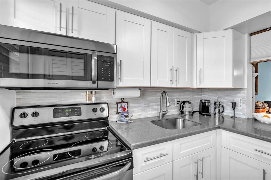 2131 Northeast 42nd Court, Unit 104E Lighthouse Point, FL 33064 - Photo 11 of 31 a kitchen with granite countertop white cabinets and stainless steel appliances