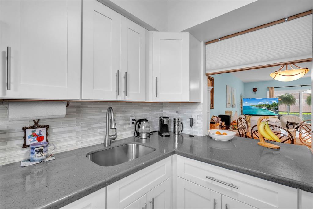 2131 Northeast 42nd Court, Unit 104E Lighthouse Point, FL 33064 - Photo 15 of 31 a kitchen with a sink and cabinets