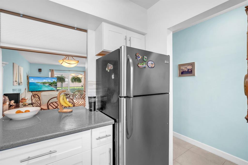 2131 Northeast 42nd Court, Unit 104E Lighthouse Point, FL 33064 - Photo 17 of 31 a kitchen with a refrigerator and sink