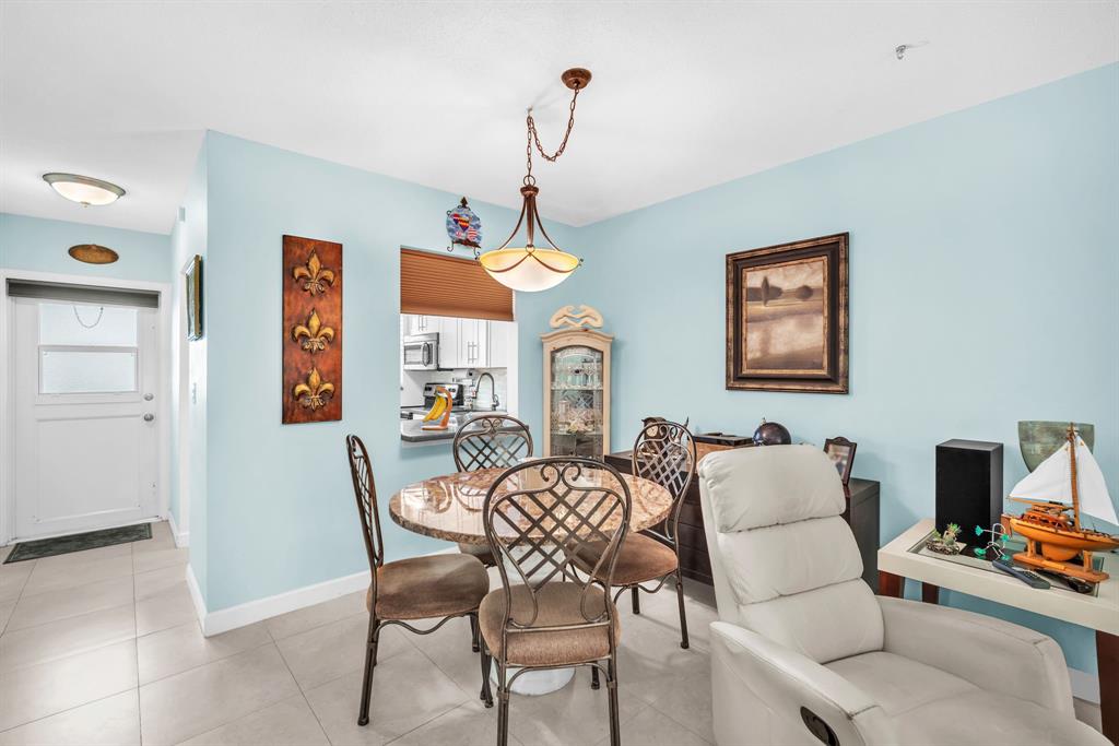 2131 Northeast 42nd Court, Unit 104E Lighthouse Point, FL 33064 - Photo 21 of 31 a dining room with furniture and window