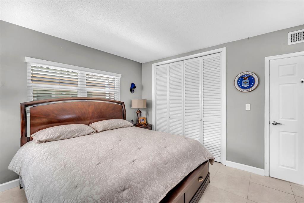 2131 Northeast 42nd Court, Unit 104E Lighthouse Point, FL 33064 - Photo 26 of 31 a bedroom with a bed and a window