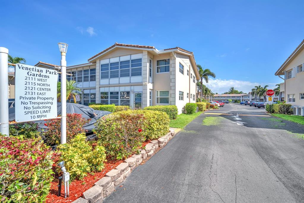2131 Northeast 42nd Court, Unit 104E Lighthouse Point, FL 33064 - Photo 27 of 31 a front view of a building with garden