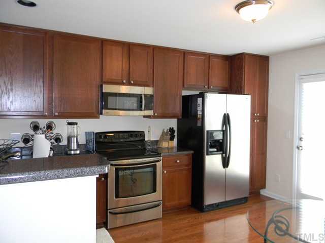 2018 Kedvale Avenue Raleigh, NC 27617 - Photo 7 of 18 a kitchen with granite countertop wooden cabinets and stainless steel appliances