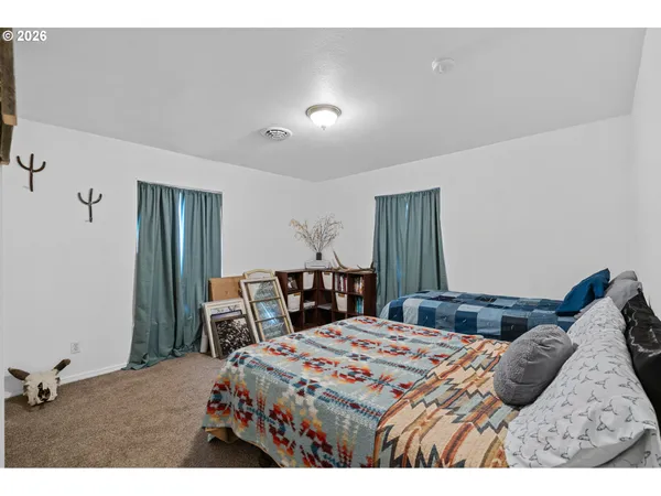 a bedroom with a bed a table and a large mirror