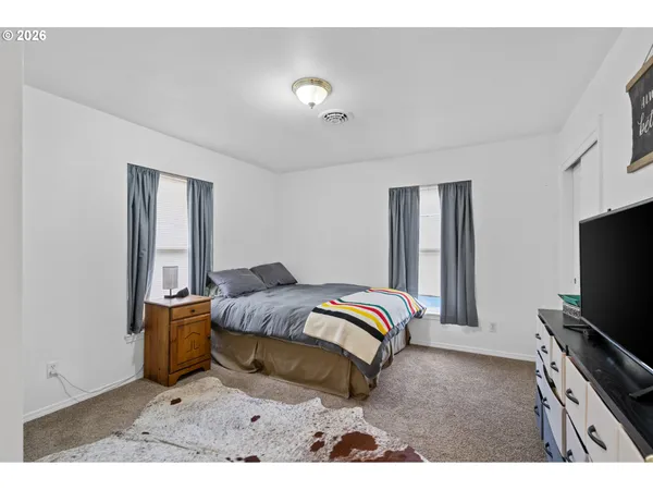 a bedroom with a bed and flat screen tv