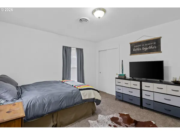 a bedroom with a bed and a flat screen tv