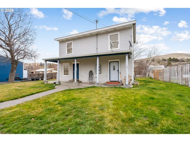 a view of a house with backyard and porch