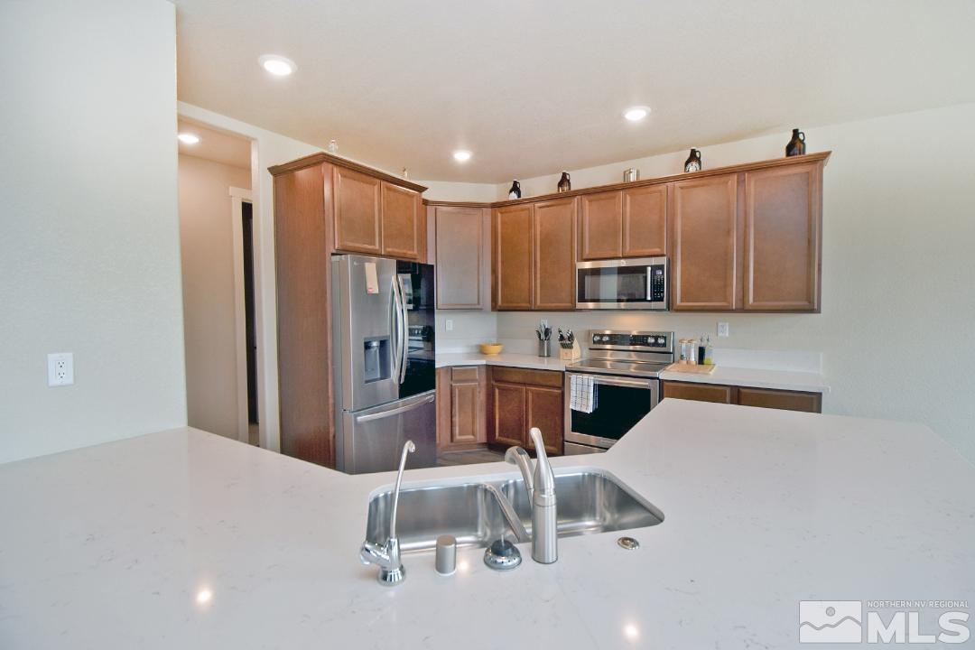 200 Paloma Ranch Court Reno, NV 89510 - Photo 8 of 27 a kitchen with granite countertop a refrigerator and a stove top oven