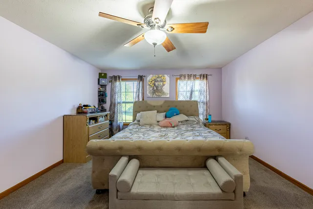 a bed sitting in a room next to a window with a chandelier